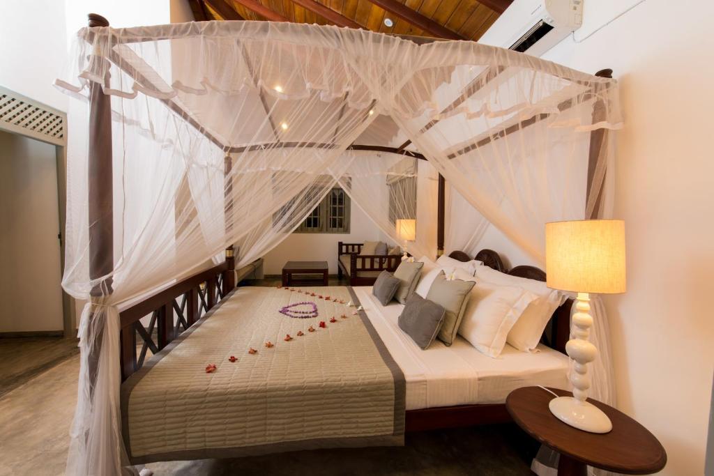 a bedroom with a bed with a canopy at The Horizon Hill Top Villa in Unawatuna