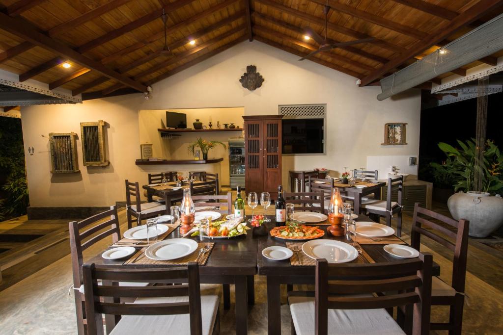 a dining room with a large wooden table and chairs at The Horizon Hill Top Villa in Unawatuna