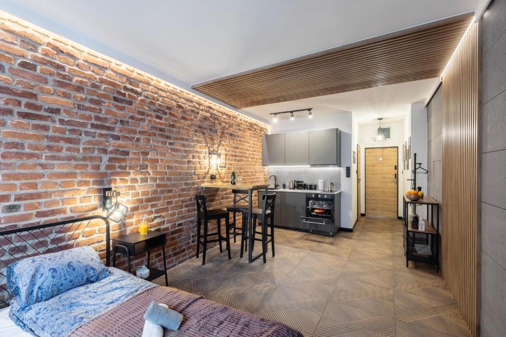 salon z ceglaną ścianą i kuchnią w obiekcie Kotlarska Snug Escape we Wrocławiu