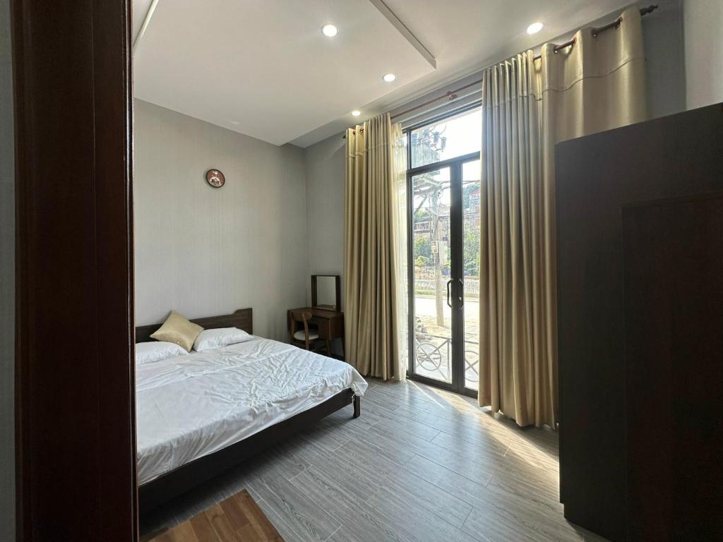 um quarto com uma cama e uma grande janela em Vũ Homestay em Cao Bang