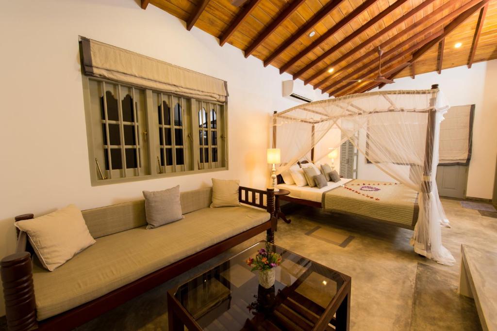 a living room with a couch and a bed at The Horizon Hill Top Villa in Unawatuna