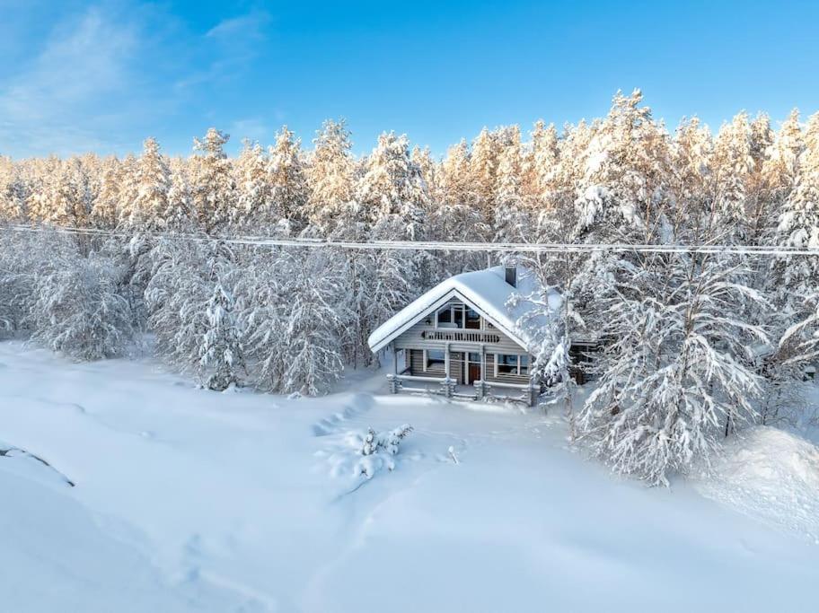 a house in the snow with trees in the background at Villa Äkäsjoensuu in Äkäslompolo