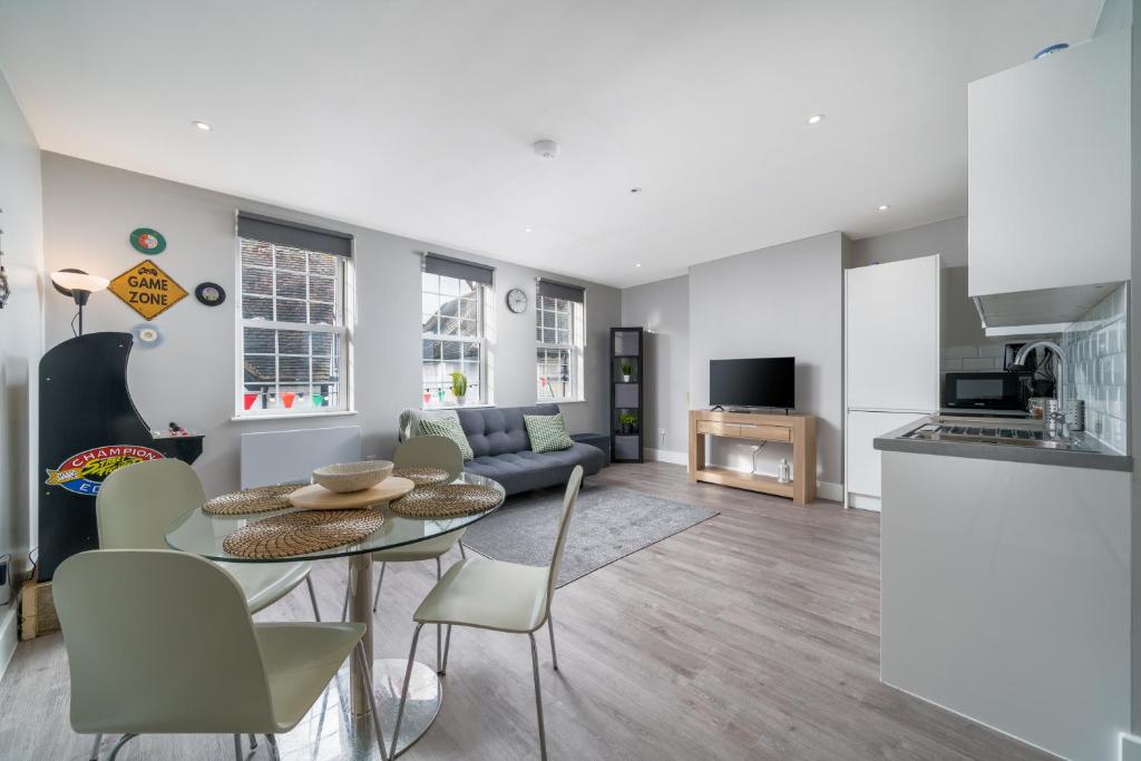 a kitchen and a living room with a table and chairs at Luxury Flat with private terrace in the Heart of Kingston in London