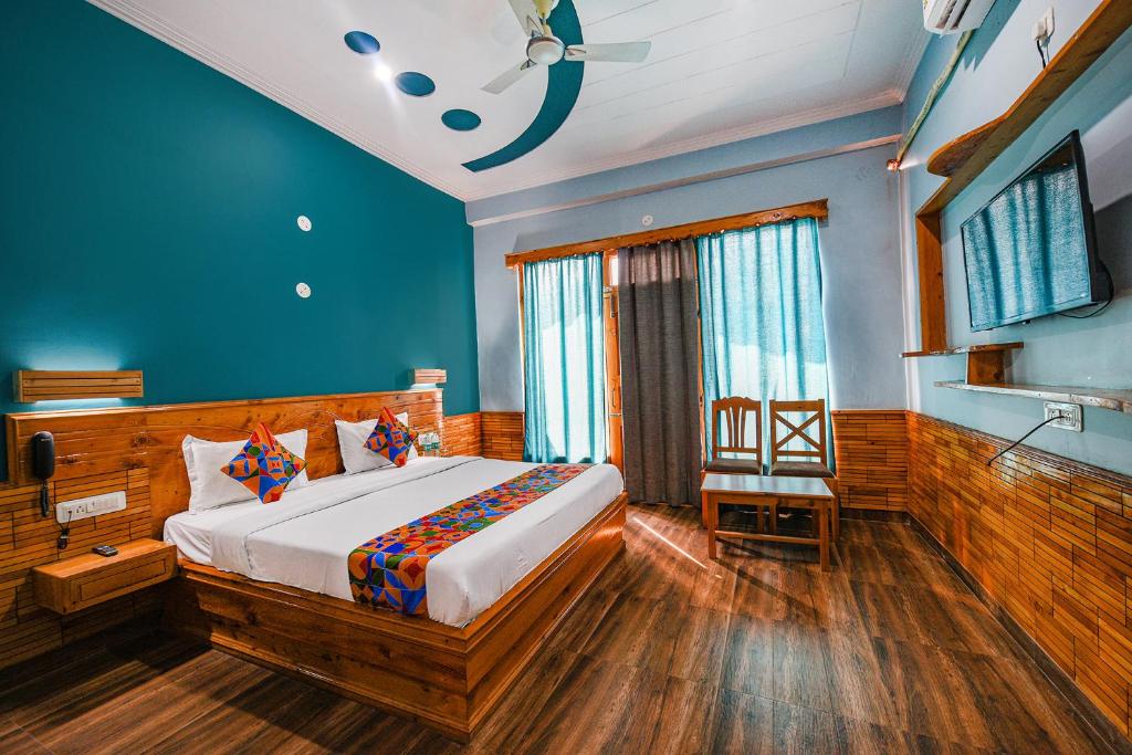 FabHotel Snower في Lārji: غرفة نوم بسرير بجدران زرقاء وارضيات خشبية