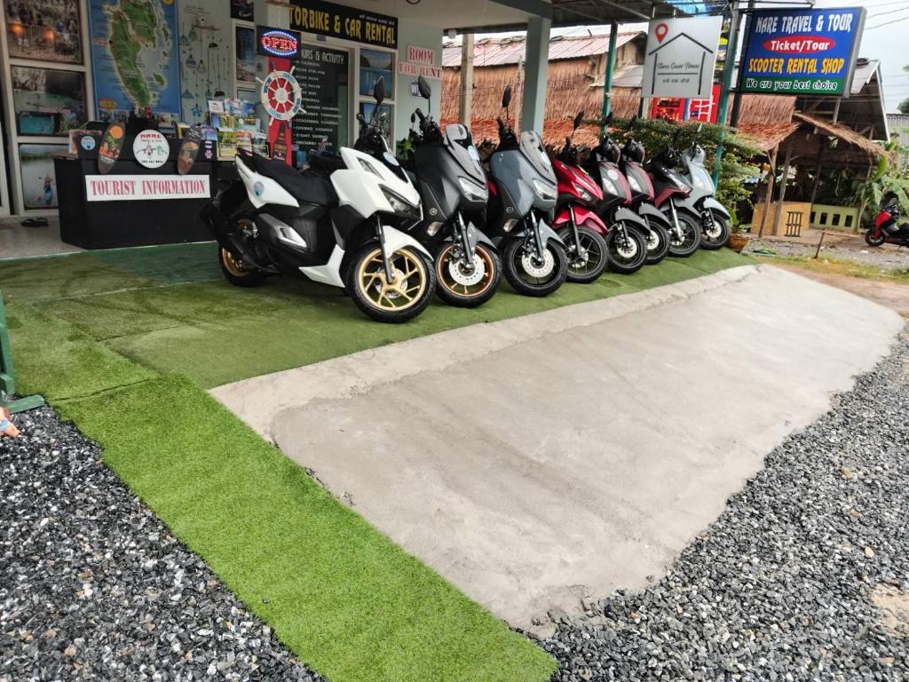 uma fila de motociclos estacionados em frente a uma loja em Nare Guest House em Ko Lanta