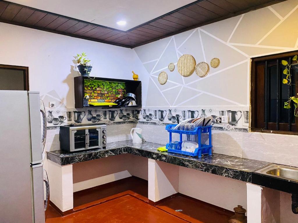 a kitchen with a counter with a tv on a wall at JUNGLE VILLA in Galle