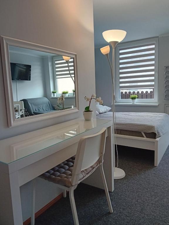 a bedroom with a desk and a large mirror at Pokoje Grażyna in Jastarnia
