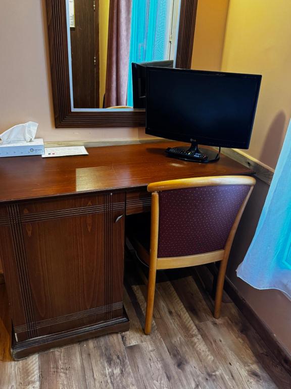 a computer monitor sitting on top of a wooden desk at 121 Paris Hotel in Paris