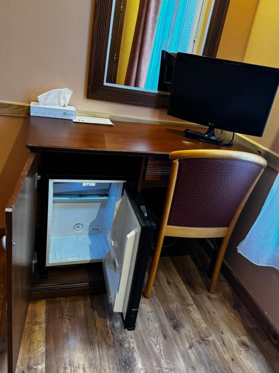 a desk with a computer monitor and a drawer at 121 Paris Hotel in Paris