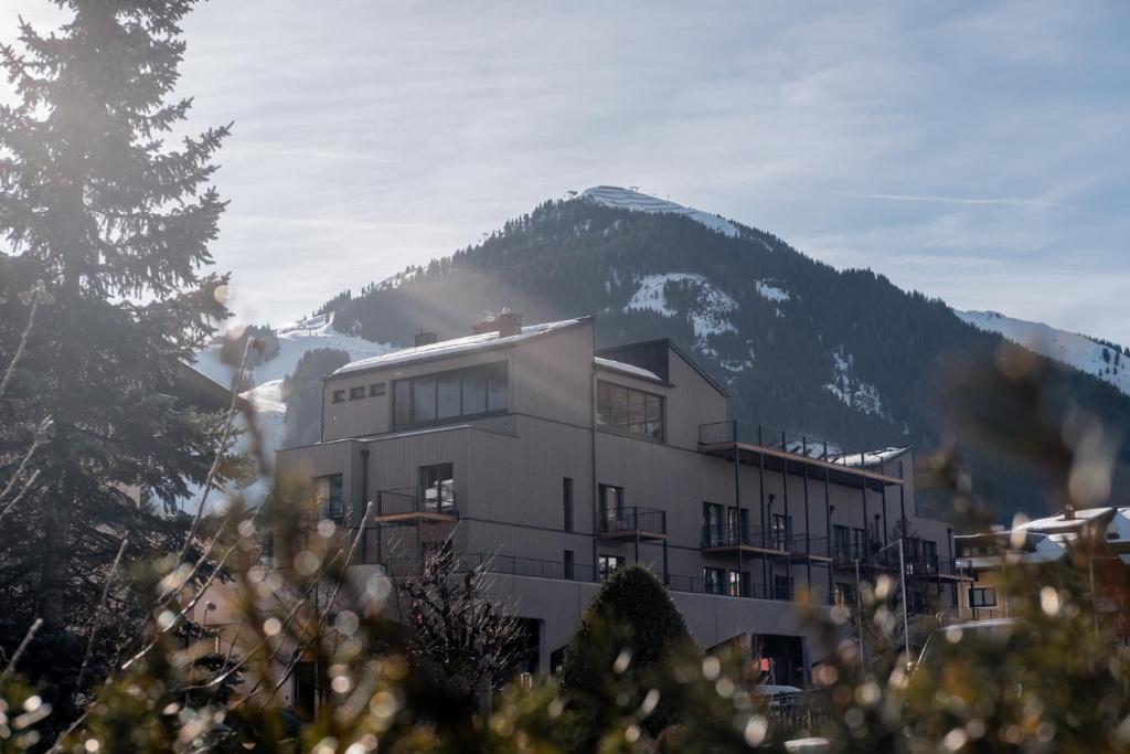 a building with a mountain in the background at kerii - adults boutique hotel in Saalbach Hinterglemm