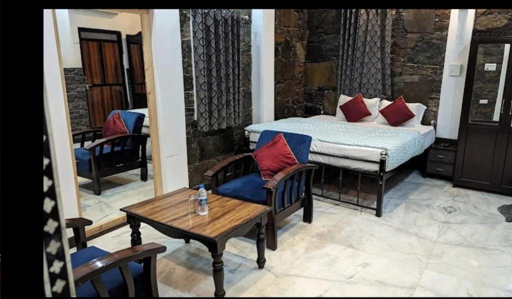 a bedroom with a bed and a table and chairs at Emperor resort by ghumo udaipur in Udaipur