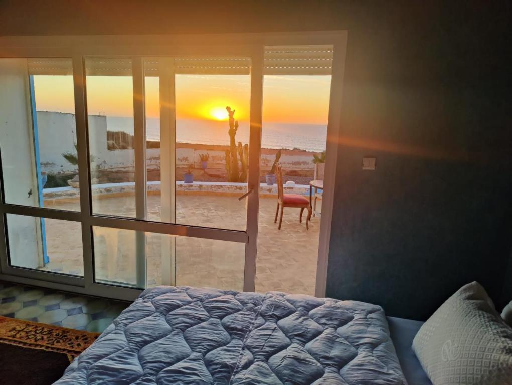 a bedroom with a bed and a view of the beach at Riad Ocean Beach Douira in Agadir