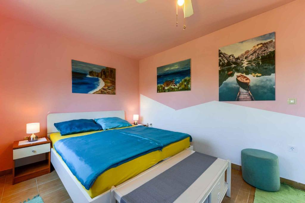 sypialnia z łóżkiem i dwoma obrazami na ścianie w obiekcie Apartments in Vir/Insel Vir 34750 w mieście Vir