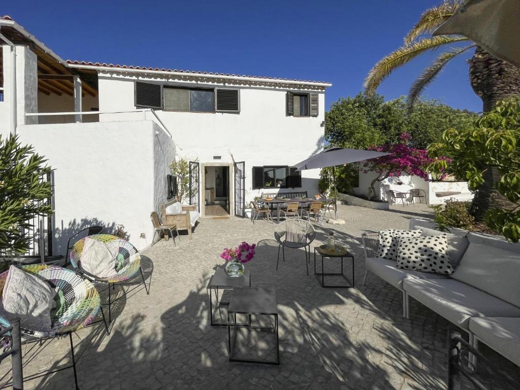 a patio with chairs and tables and a building at Casa Estrela in Loulé