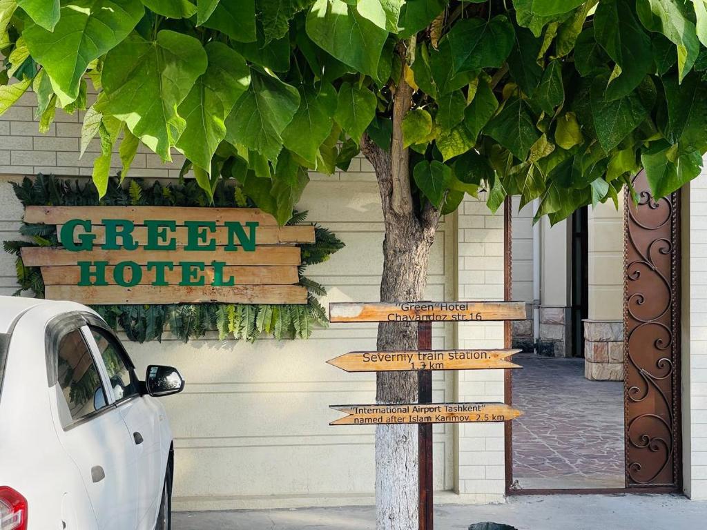 um sinal de rua em frente a um hotel em Green Hotel em Tashkent