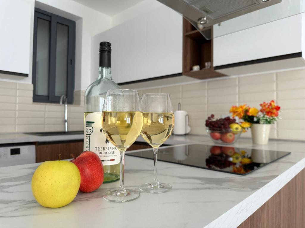 - deux verres de vin blanc et de fruits sur un comptoir de cuisine dans l'établissement New, airy and spacious apartment in Mellieha, à Mellieħa