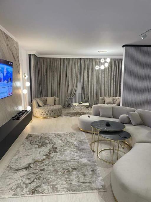 Apartament Luxury Promenada في كرايوفا: غرفة معيشة مع أريكة وتلفزيون
