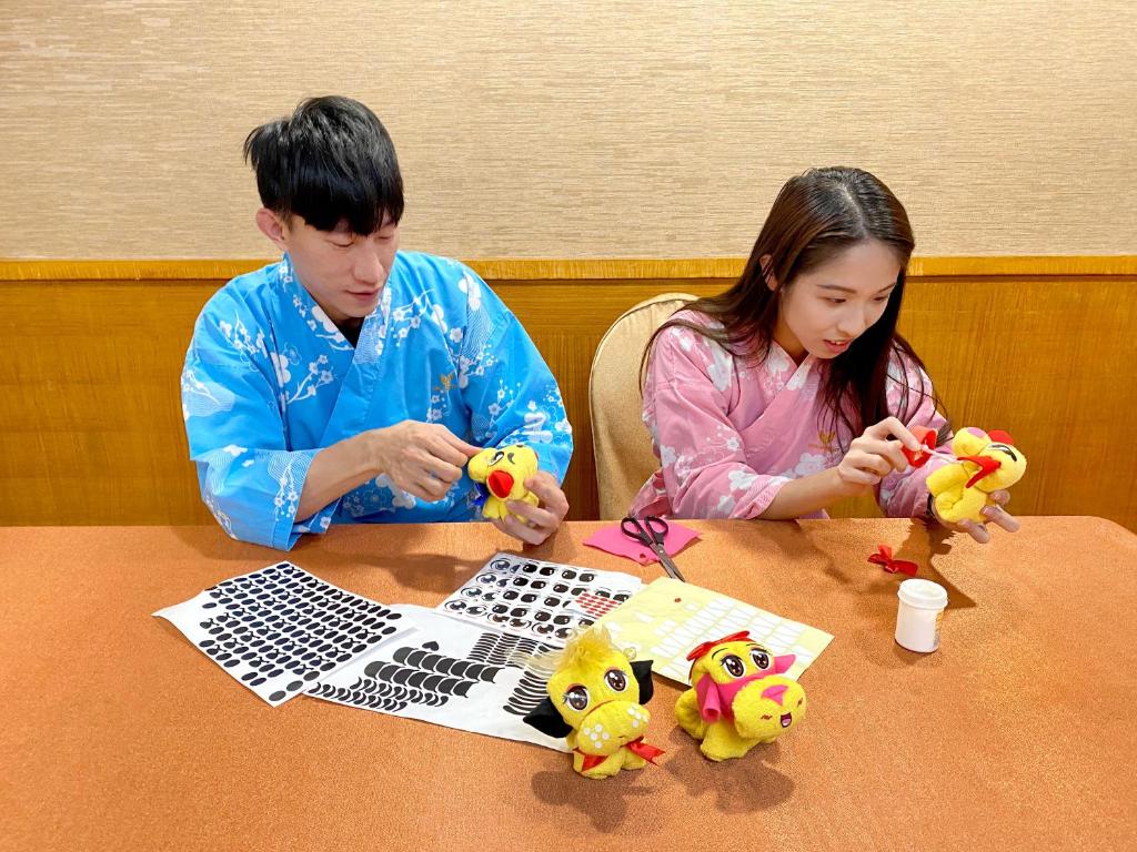two people sitting at a table playing with toy animals at Uni-Resort Ku-Kuan in Heping