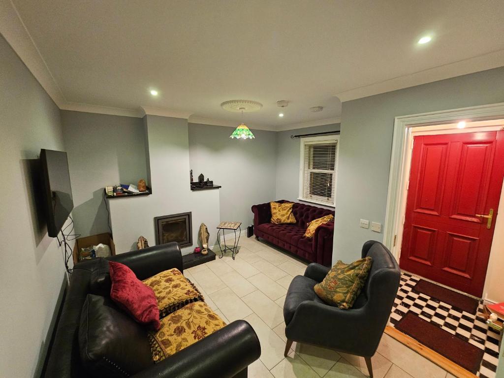uma sala de estar com dois sofás e uma porta vermelha em Central Westport Town House em Westport