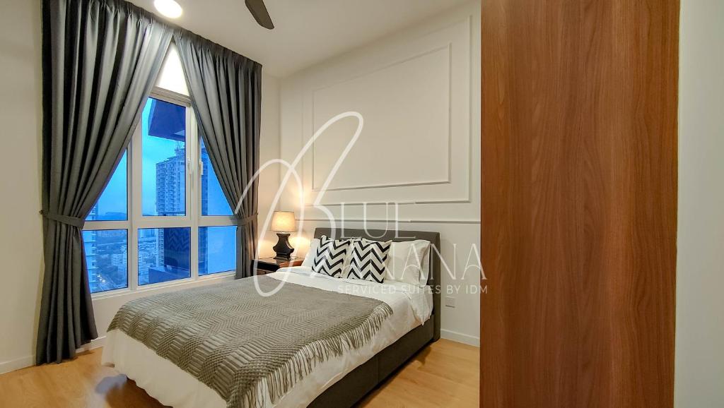 ein Schlafzimmer mit einem Bett und einem großen Fenster in der Unterkunft Inspirasi Mont Kiara Premier Suites by BlueBanana in Kuala Lumpur