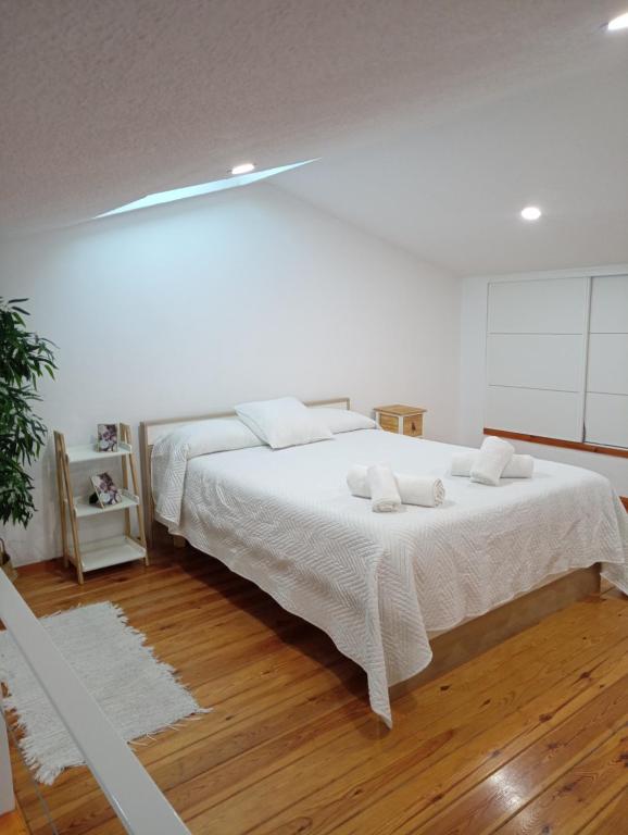 a white bedroom with a large bed with white sheets at Sevilla BRISAS VIP Valencina de la concepción in Seville