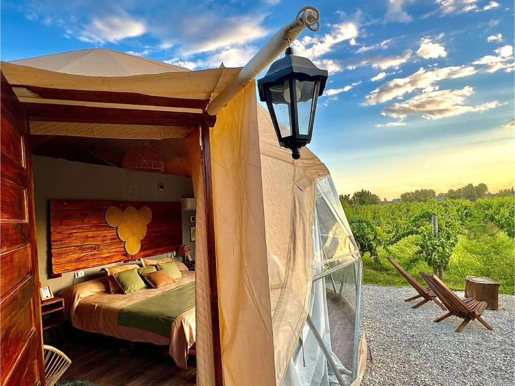 a tent with a bed and a street light at Entre racimos, glamping entre viñedos in Ciudad Lujan de Cuyo