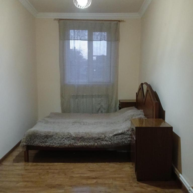 um quarto com uma cama em frente a uma janela em Дом для гостей em Guiumri