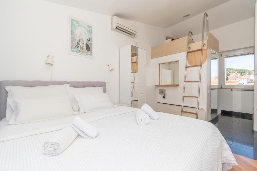a bedroom with a large white bed with towels on it at Rooms Gold in Split