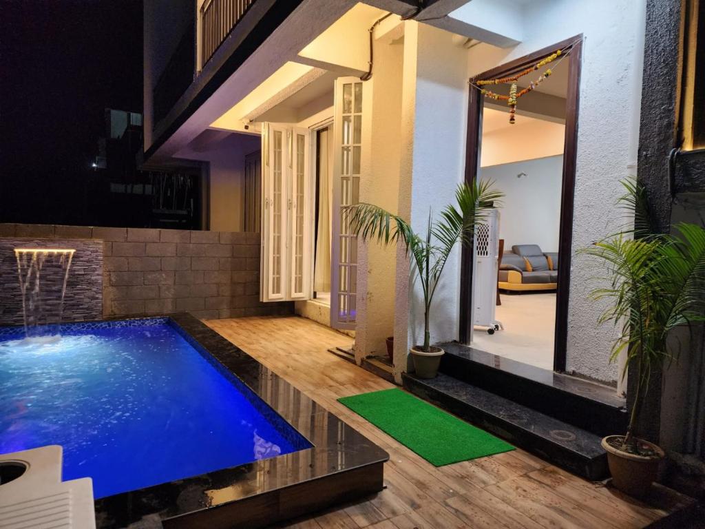 a house with a swimming pool in the middle of a yard at Twilight Villa ll Swimming Pool ll AC ll BBQ ll 2BHK in Lonavala