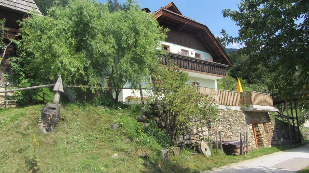 ein Haus auf einem Hügel mit einem Baum in der Unterkunft Apartments Berghof Familie Steinwender in Pölling