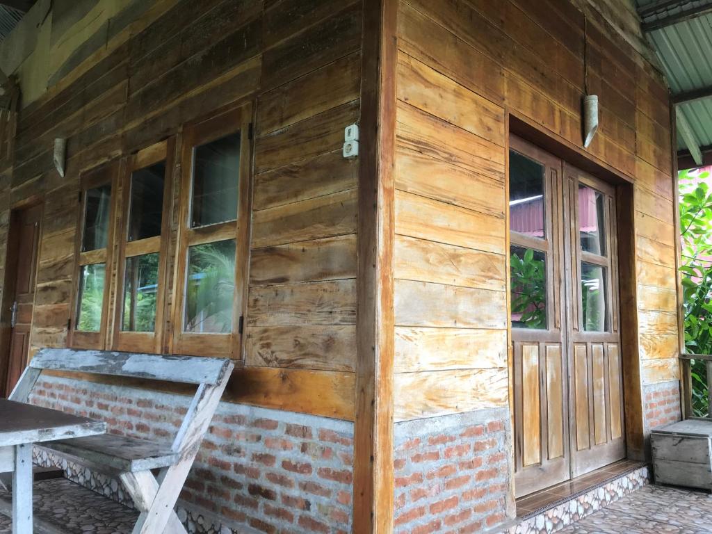 a wooden house with a wooden door and a chair at Dolin Cottage in Hilibotodane