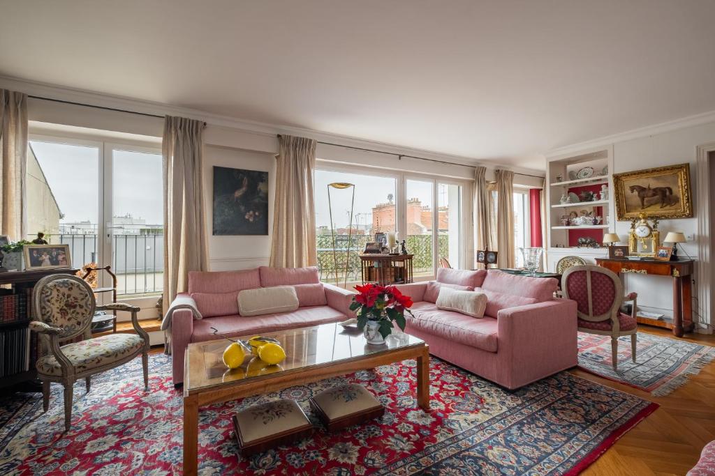 salon z 2 różowymi kanapami i stołem w obiekcie Veeve - A Study in Pink w mieście Boulogne-Billancourt