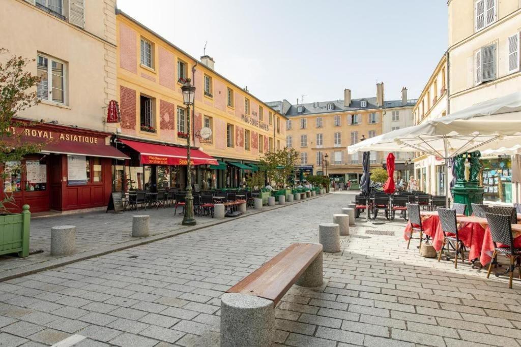 una calle de la ciudad con mesas, sillas y edificios en Appartement en centre ville de Versailles, en Versalles
