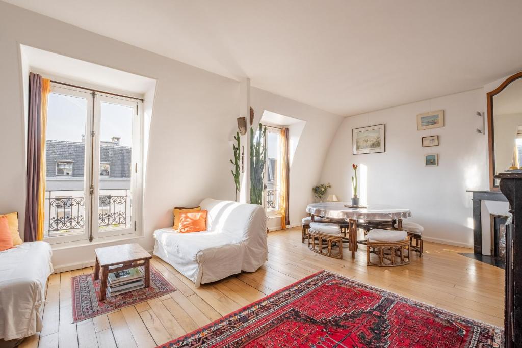 un salon avec un canapé blanc et une table dans l'établissement Veeve - Theatre in the Sky, à Paris