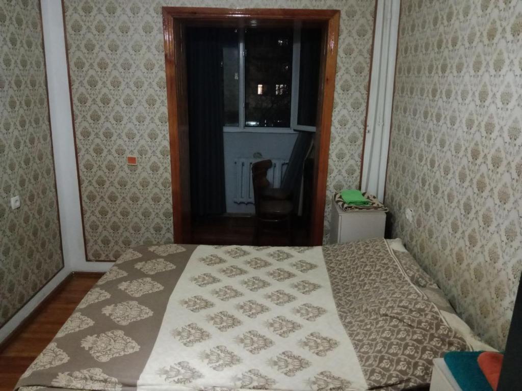 Un dormitorio con una cama con una manta. en markaz 6 Uy-122A Honadon-9, en Tashkent