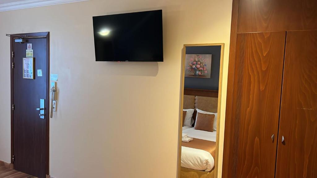 a room with a tv on the wall and a closet at 121 Paris Hotel in Paris