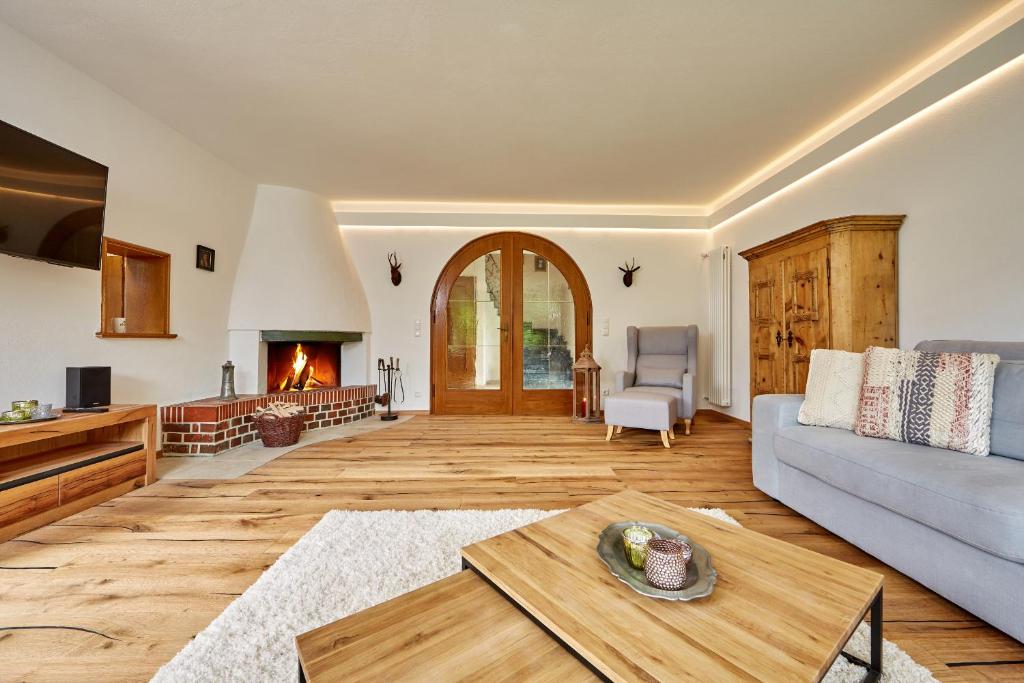 Villa Bruni في غارميش - بارتنكيرشين: غرفة معيشة مع أريكة ومدفأة