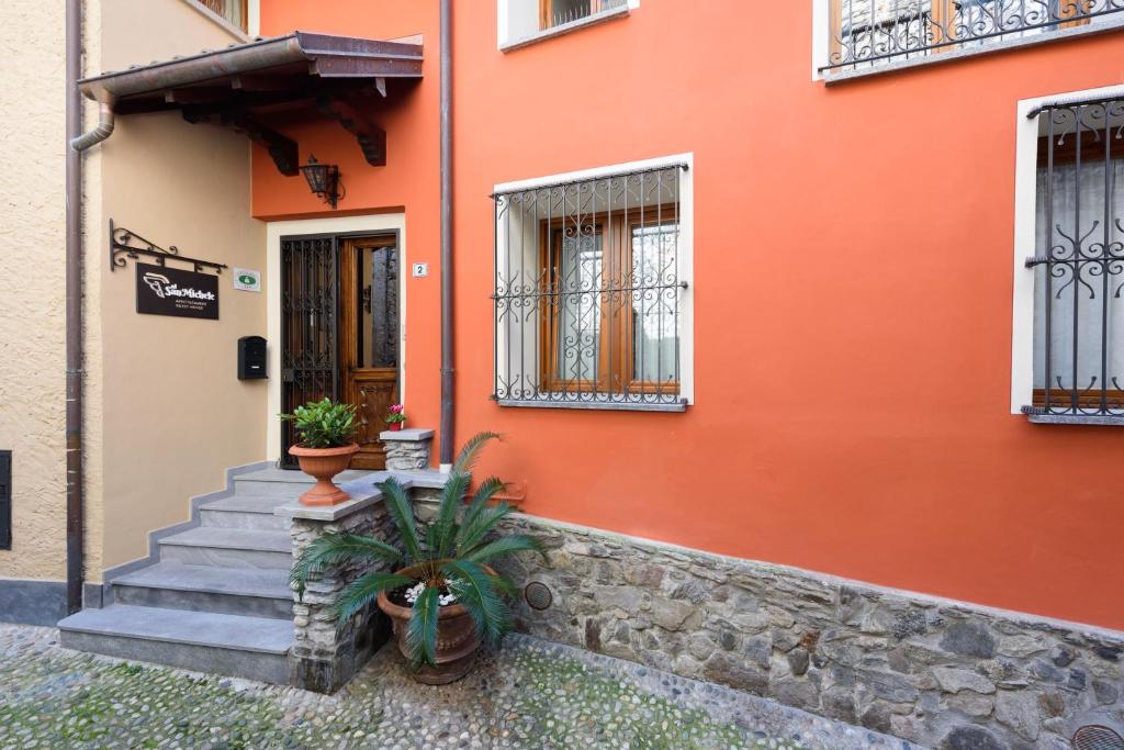 a orange building with stairs and a door at Al San Michele in Stresa