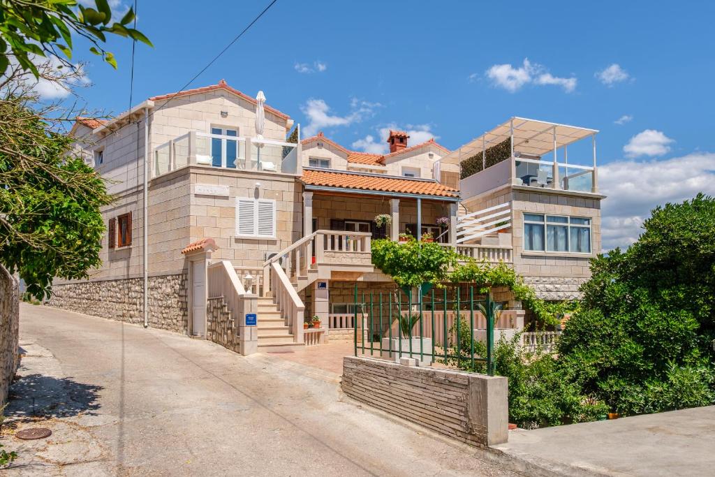 a large house with a staircase in front of it at Apartman Mirna in Sumartin