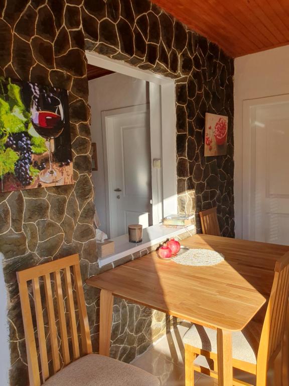 a dining room with a wooden table and a stone wall at Ferienhaus Brice / Mostar in Mostar