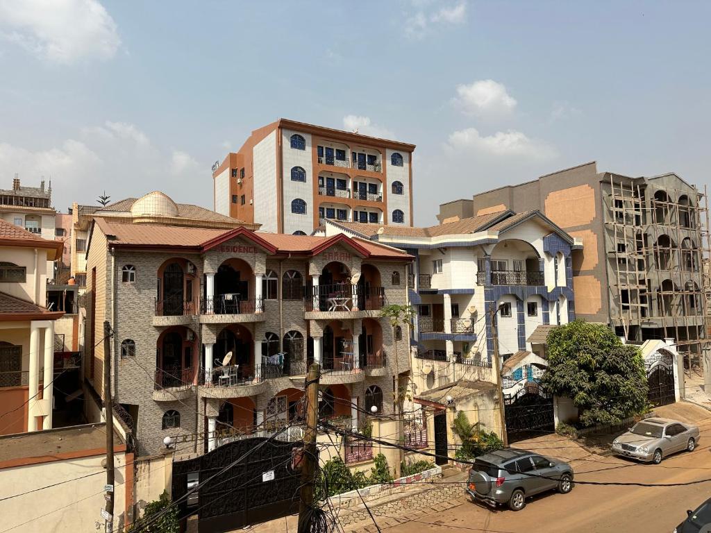 a group of buildings with cars parked on a street at Kc luxury in Yaoundé