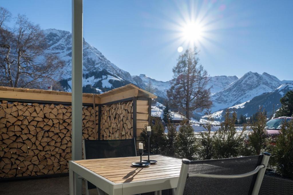 un tavolo e sedie su un balcone con vista sulle montagne di Alpen Bijou mit Bergkulisse & Liebe zum Detail ad Adelboden