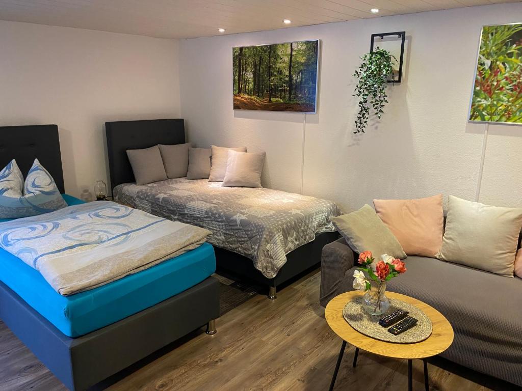 Apartment Mette في ماين: غرفة معيشة بها سريرين وأريكة