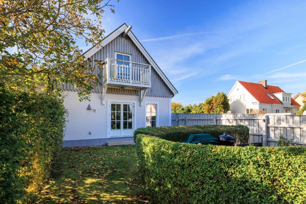 Cette maison blanche dispose d'un balcon et d'une clôture. dans l'établissement Gamla Viken, 150 qm, 3 bedroom, 6 beds, à Viken