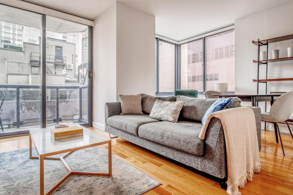 a living room with a couch and a table at Midtown 1br w doorman gym nr Times Square NYC-1208 in New York