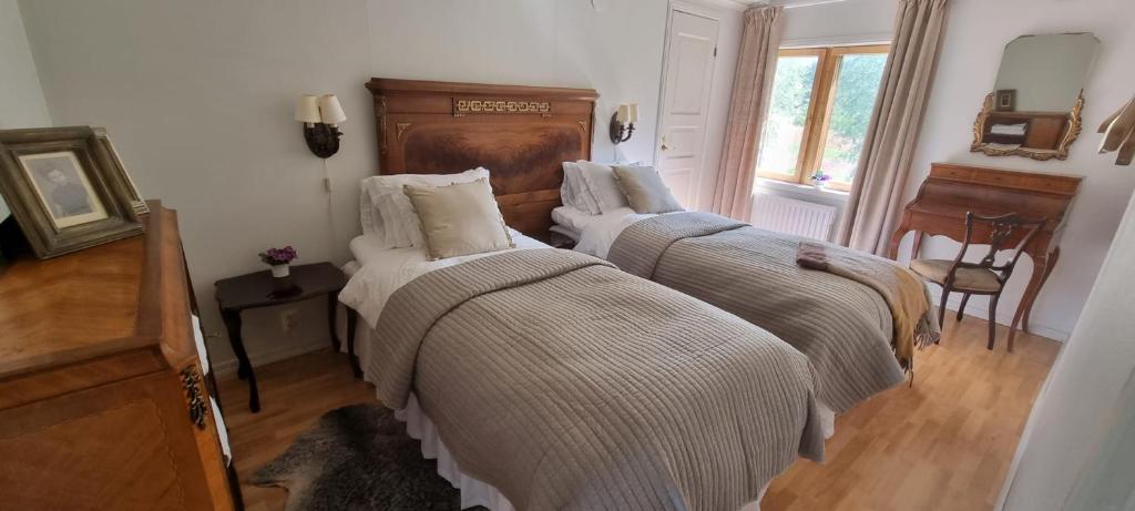 1 dormitorio con 2 camas y ventana en Villa Söder, en Ojakkala