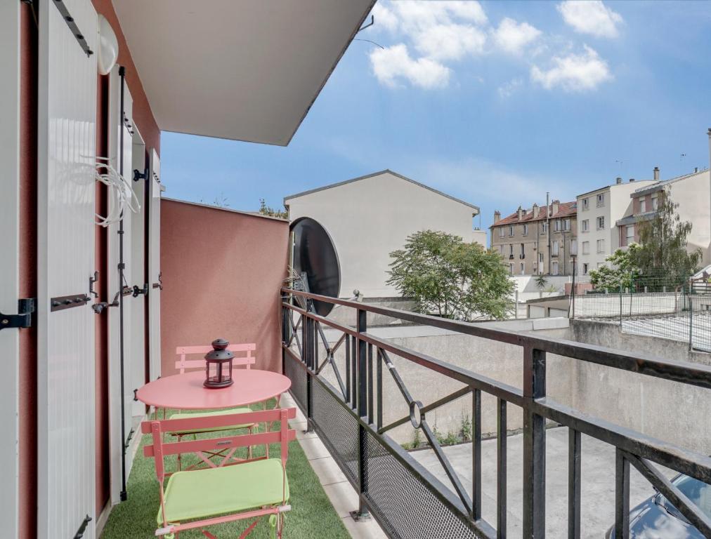 a balcony with a pink table and a chair at Chic apart with parking and balcony near Paris in Aubervilliers