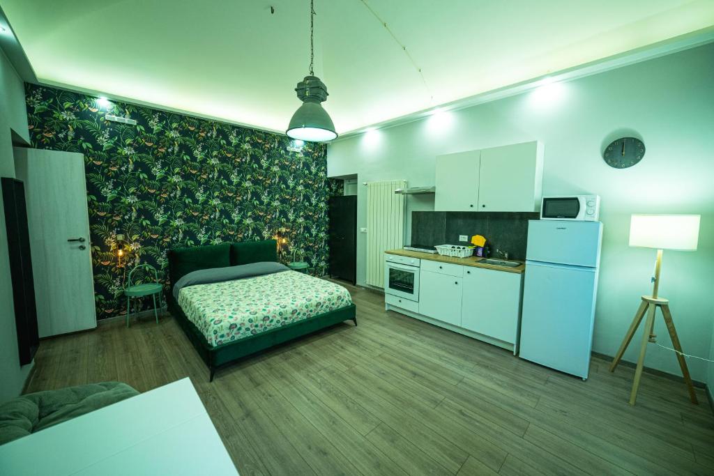 uma sala de estar com uma cama e uma cozinha em Regis 2 Appartamenti Resort centro storico em Chivasso