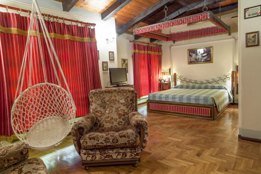 um quarto com uma cama e uma cadeira em Hotel Villino Della Flanella em Módena