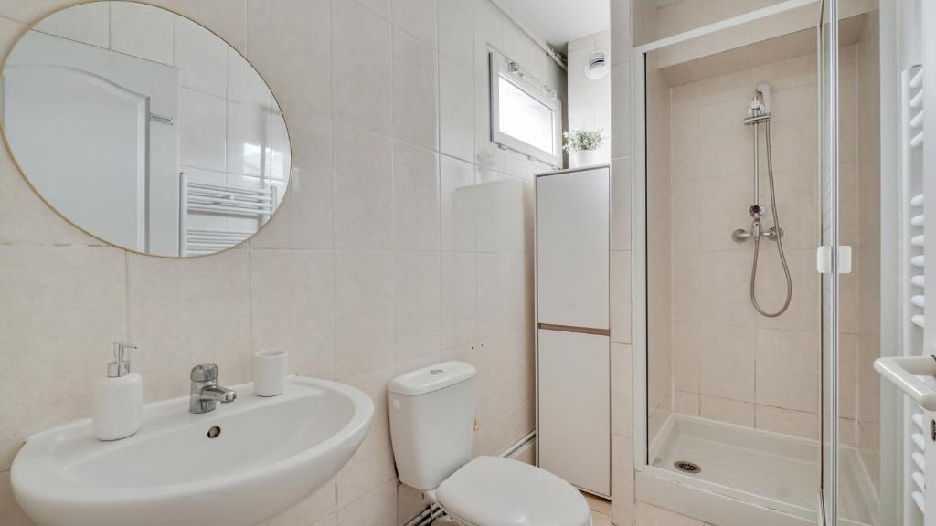 a bathroom with a sink and a toilet and a mirror at Chic apart with parking and balcony near Paris in Aubervilliers